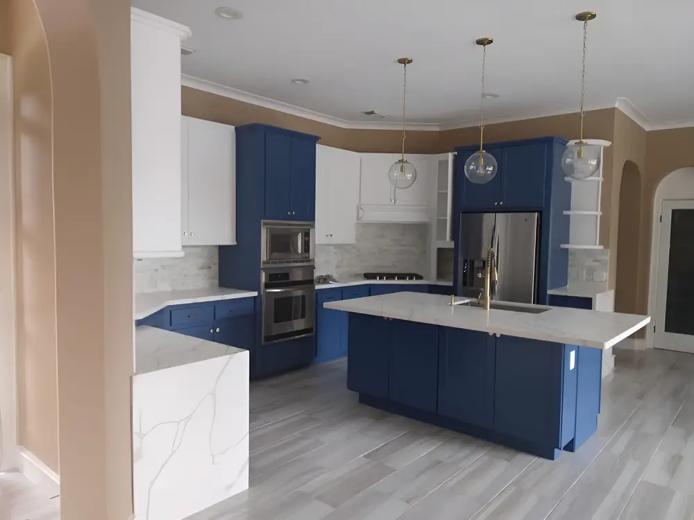 Kitchen with beige walls, white crown molding and blue lower cabinets