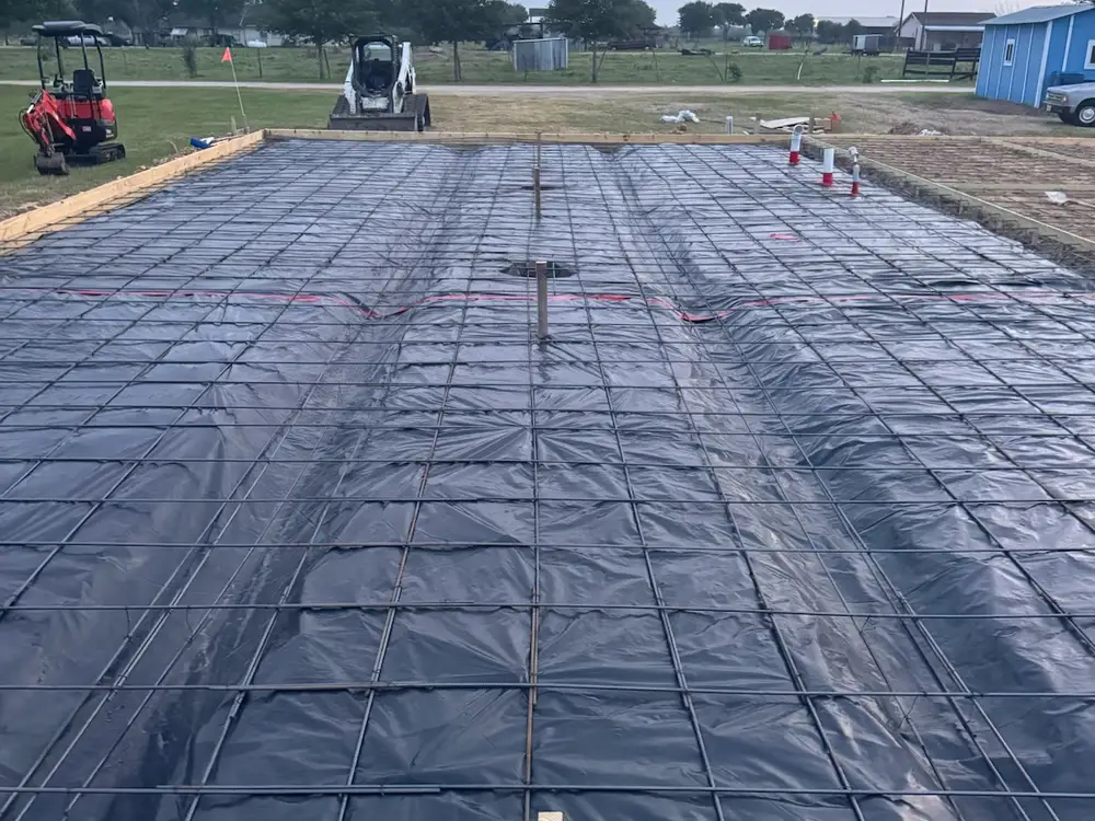 Slab area prepared with a vapor barrier and rebar grid before the pour