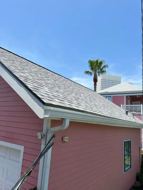 Gray shingle roof on a two-story house with red siding