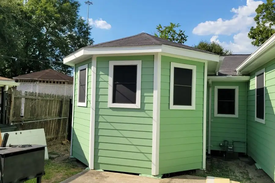 Green lap siding with white trim on an angled home addition