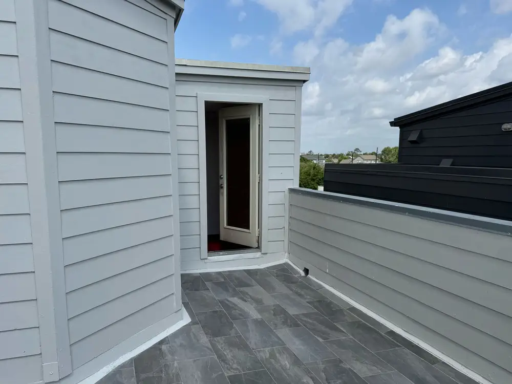 White lap siding and trim around a rooftop terrace door
